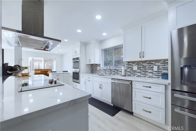 kitchen with tasteful backsplash, stainless steel appliances, island range hood, sink, and white cabinetry