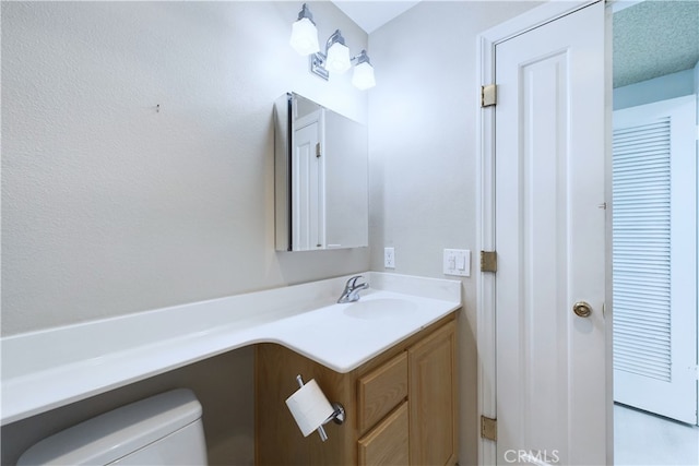 bathroom featuring toilet and vanity