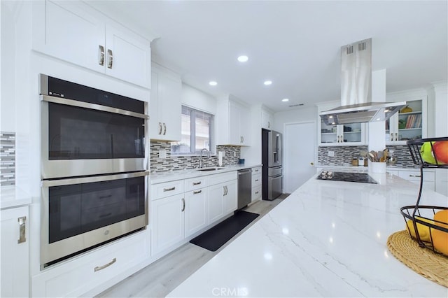 kitchen featuring white cabinetry, light stone countertops, stainless steel appliances, and island exhaust hood