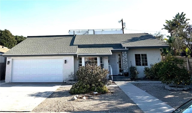 single story home featuring a shingled roof, concrete driveway, an attached garage, and stucco siding