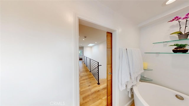 bathroom featuring a soaking tub and wood finished floors