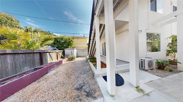 view of side of property with ac unit, a patio area, a fenced backyard, and stucco siding