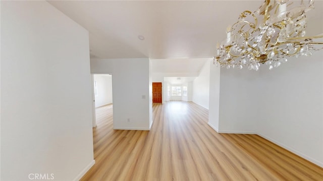 spare room featuring baseboards and light wood-style floors