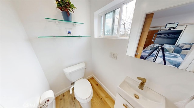 bathroom with vanity, wood finished floors, toilet, and baseboards