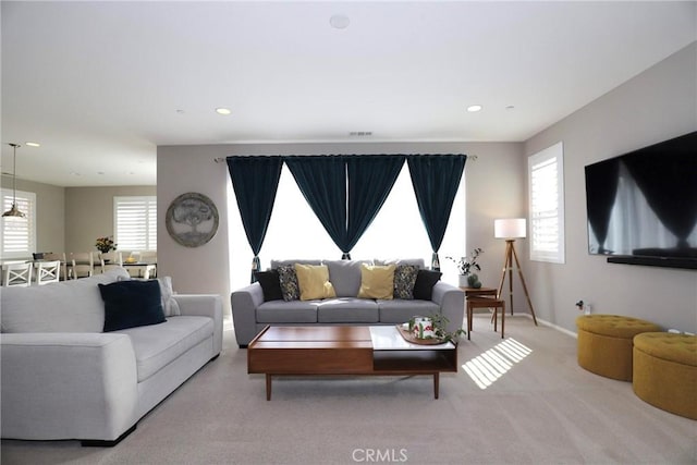 living room featuring baseboards, recessed lighting, visible vents, and a healthy amount of sunlight