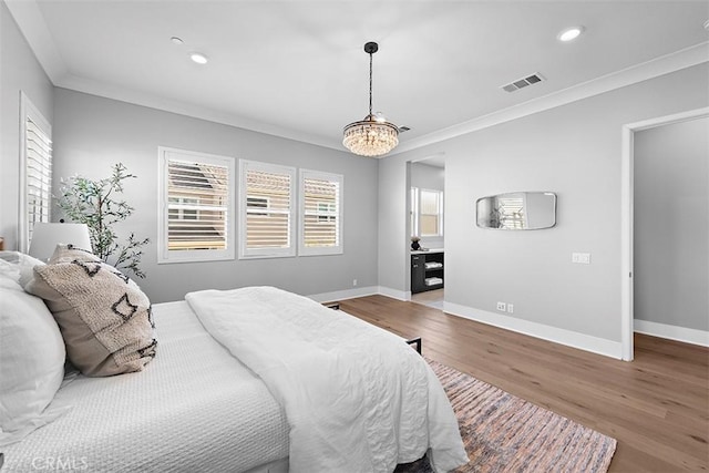 bedroom featuring hardwood / wood-style floors, an inviting chandelier, and ornamental molding