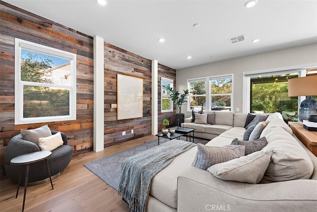 living room featuring light hardwood / wood-style floors and wood walls