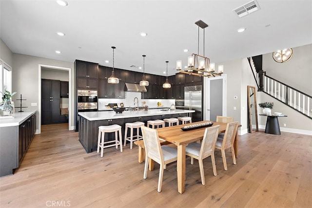 dining room featuring sink, light hardwood / wood-style floors, and an inviting chandelier