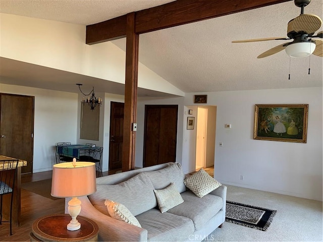 living room with ceiling fan, lofted ceiling with beams, carpet floors, and a textured ceiling