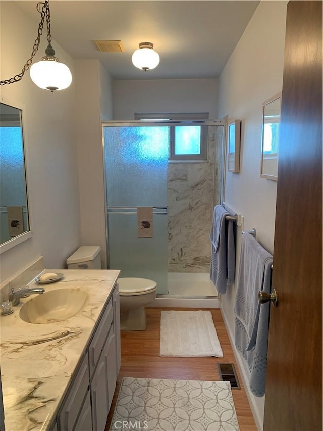 bathroom featuring hardwood / wood-style flooring, vanity, and a shower with door