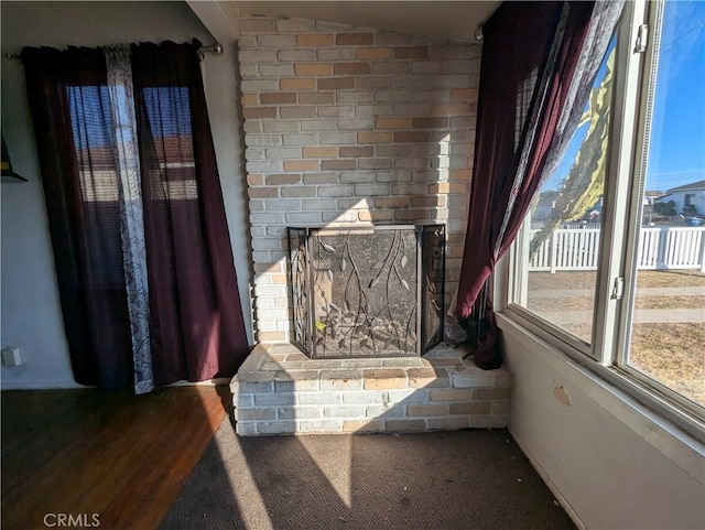 details with a brick fireplace and hardwood / wood-style flooring