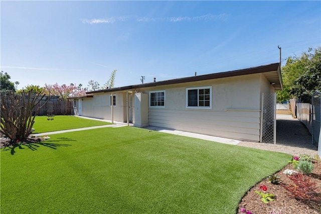 rear view of house featuring a yard