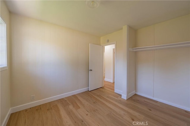 unfurnished bedroom with light hardwood / wood-style flooring and a closet