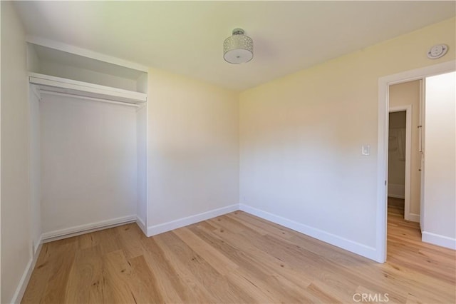 unfurnished bedroom featuring light wood-type flooring and a closet