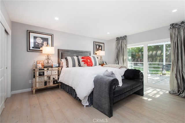 bedroom with access to exterior, light hardwood / wood-style floors, and a closet