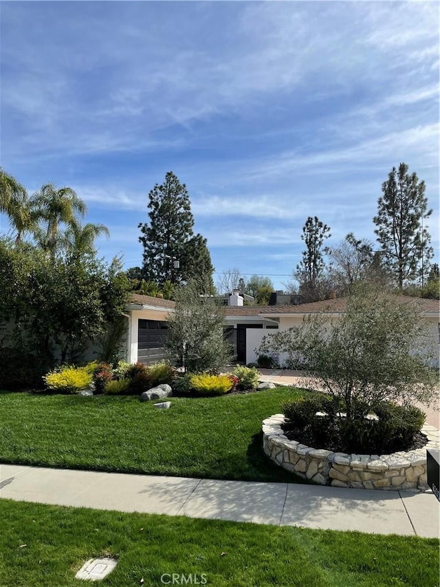 view of front of home with a front yard and a garage