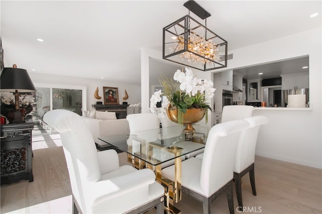 dining space featuring light wood-type flooring and a chandelier