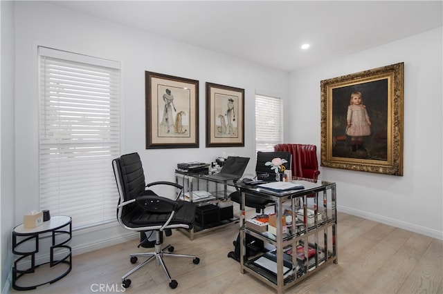 home office with light hardwood / wood-style floors