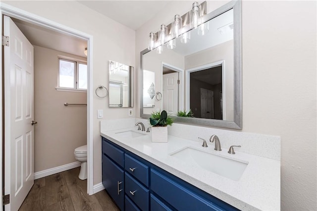 bathroom featuring toilet, hardwood / wood-style flooring, and vanity