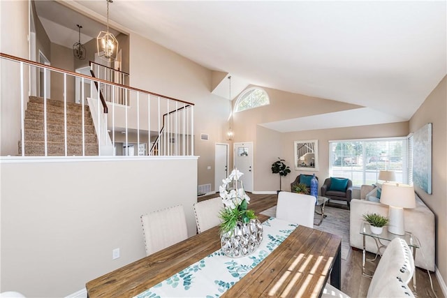 dining room featuring a notable chandelier, high vaulted ceiling, and wood-type flooring