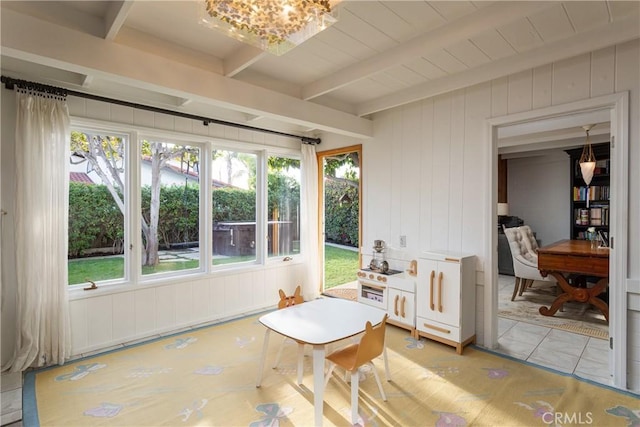 sunroom with beam ceiling and an inviting chandelier