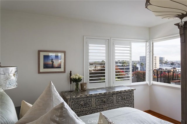 bedroom with a city view and wood finished floors