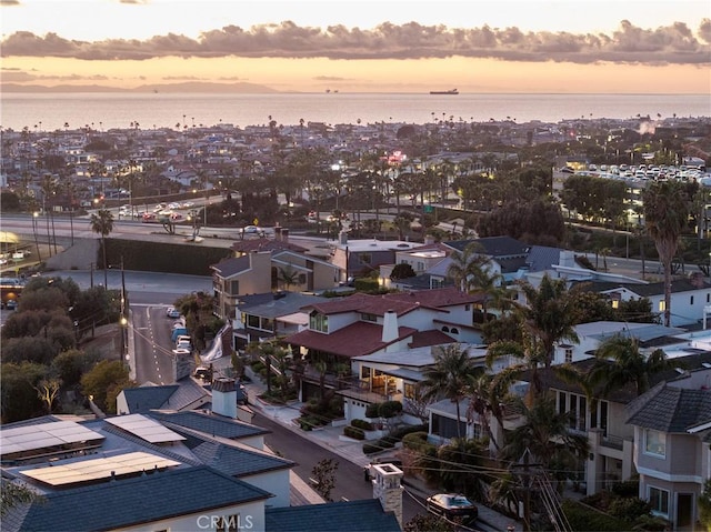 aerial view at dusk featuring a water view