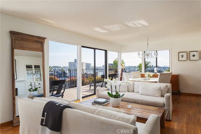 living room with a chandelier, baseboards, wood finished floors, and a city view