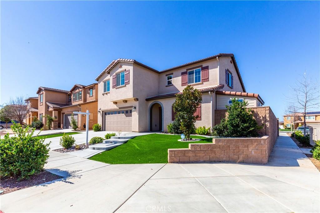 mediterranean / spanish-style house featuring a residential view, a tile roof, stucco siding, driveway, and an attached garage