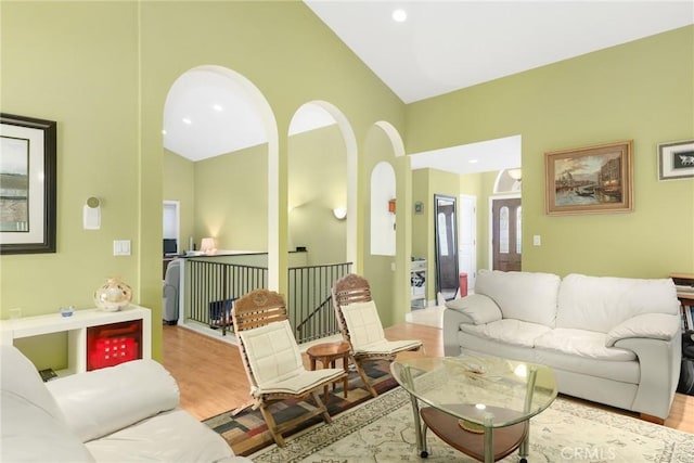 living room featuring lofted ceiling and light hardwood / wood-style flooring