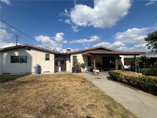 back of property featuring a lawn and a carport