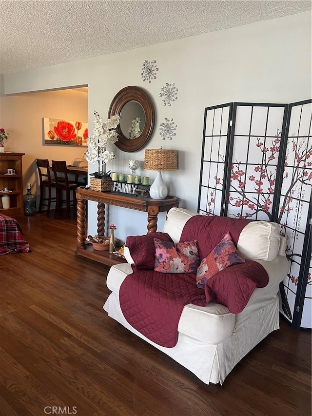 living area with dark hardwood / wood-style flooring and a textured ceiling