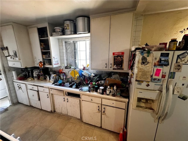 kitchen featuring white fridge with ice dispenser and light tile patterned floors