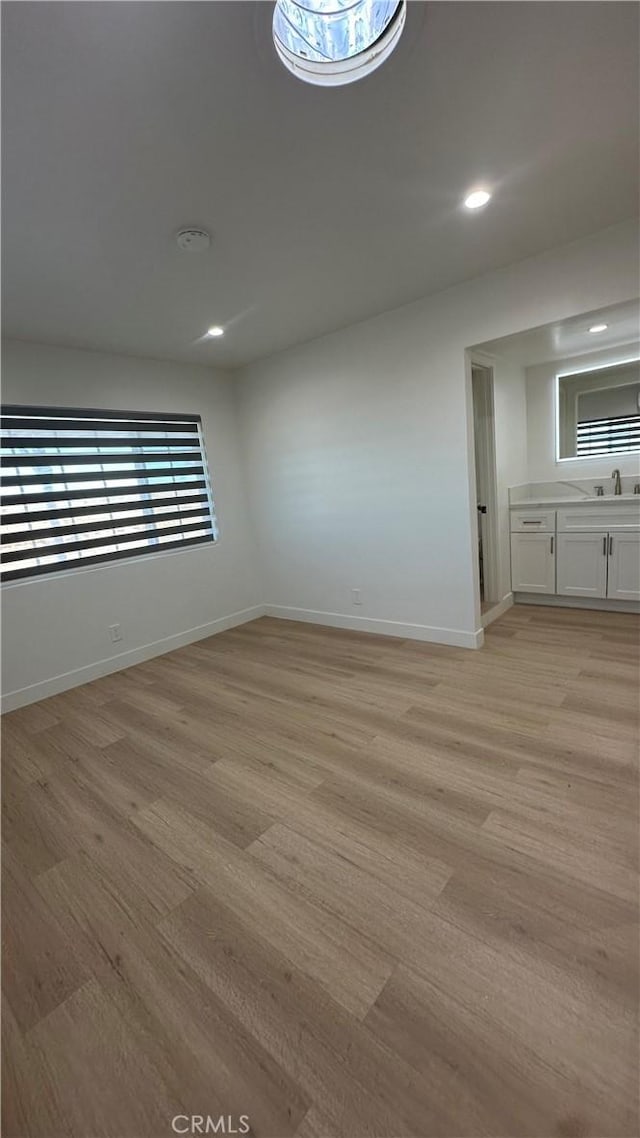 empty room with sink and light hardwood / wood-style floors