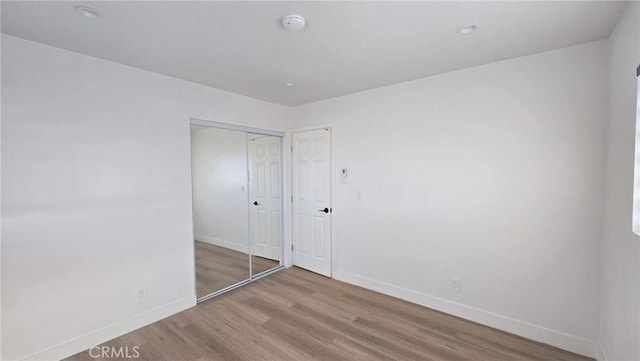 unfurnished bedroom featuring hardwood / wood-style floors and a closet