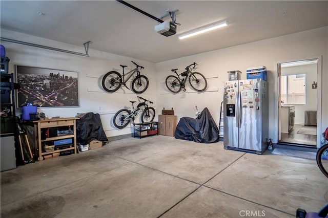 garage featuring a garage door opener and stainless steel fridge