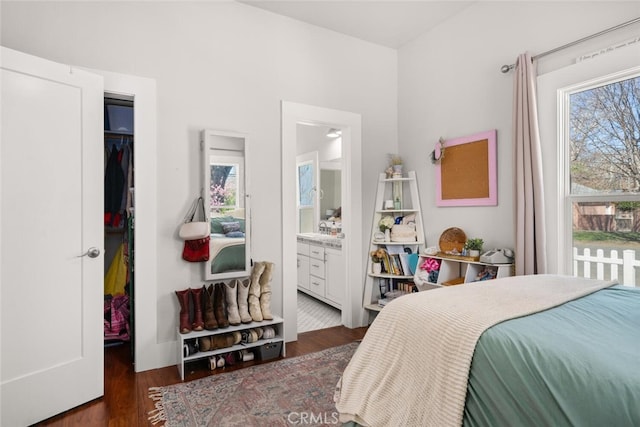 bedroom featuring a spacious closet, ensuite bathroom, a closet, and wood finished floors