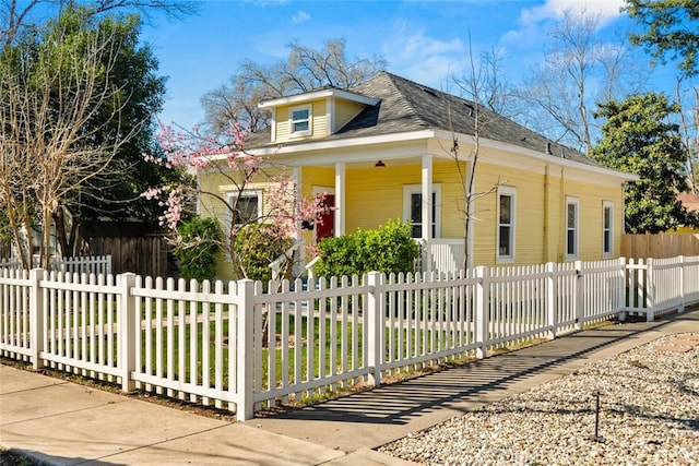 bungalow-style home featuring a fenced front yard and covered porch