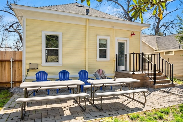 back of house with a patio area, fence, and roof with shingles