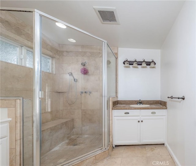 full bathroom with a stall shower, tile patterned flooring, vanity, and visible vents