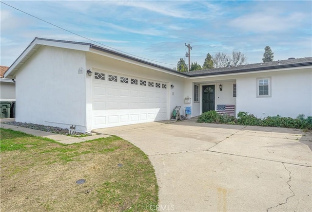 ranch-style house with a garage, driveway, a front yard, and stucco siding