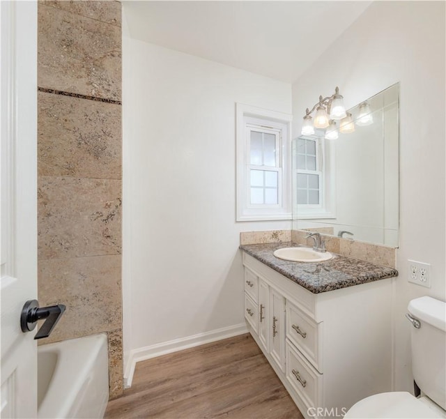 full bathroom with toilet, baseboards, wood finished floors, and vanity