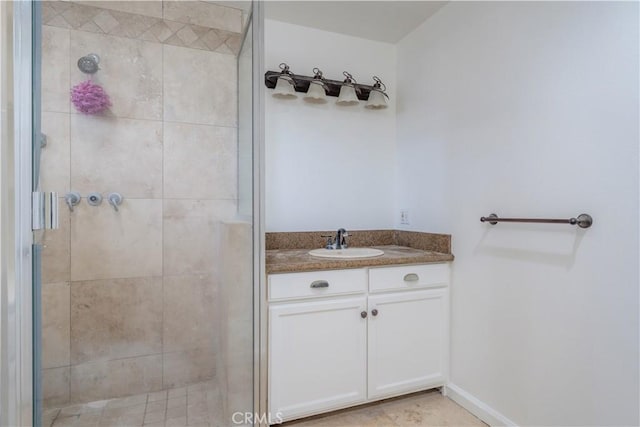 bathroom featuring a shower stall, baseboards, and vanity