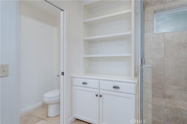 full bath with built in shelves, a stall shower, toilet, and tile patterned floors