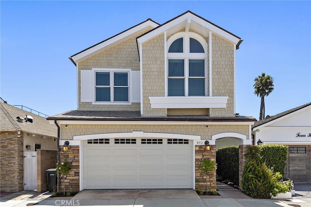 view of front of property with an attached garage, stone siding, and concrete driveway