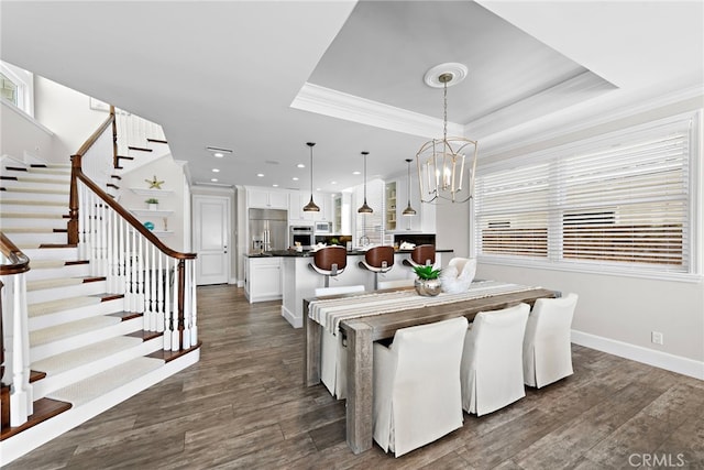 dining area featuring crown molding, stairs, a raised ceiling, and dark wood-type flooring