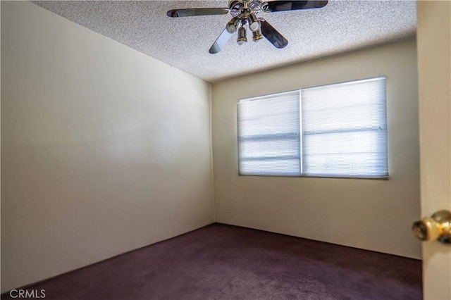 unfurnished room featuring a textured ceiling, dark colored carpet, and ceiling fan