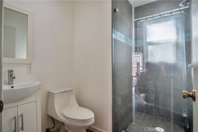 bathroom featuring vanity, a shower with door, and toilet