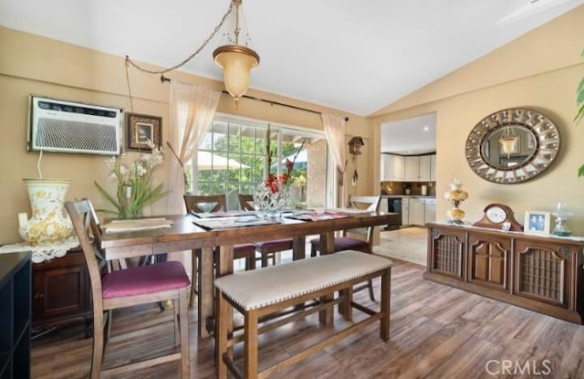 dining room with vaulted ceiling, an AC wall unit, and wood finished floors