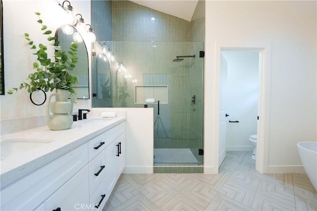 bathroom featuring double vanity, a stall shower, a sink, vaulted ceiling, and toilet